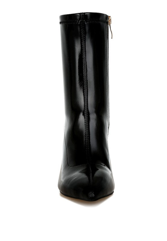 Black patent faux-leather tall boot, back view with side-stitching and gold geometric heel