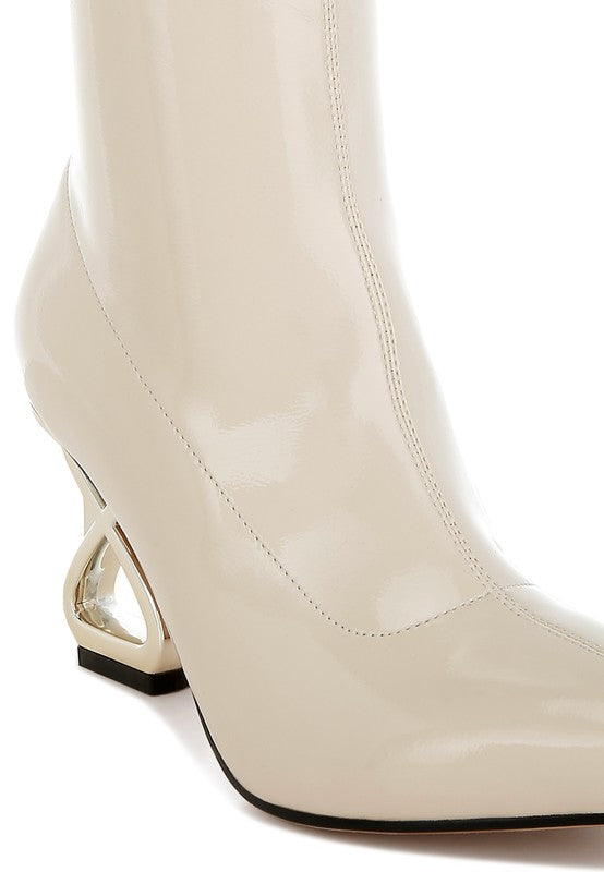Beige patent faux-leather boot side close-up with gold geometric block heel