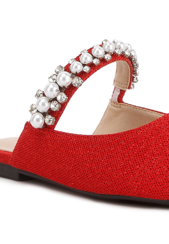 Red textured mule close-up with pearl-and-rhinestone embellished strap