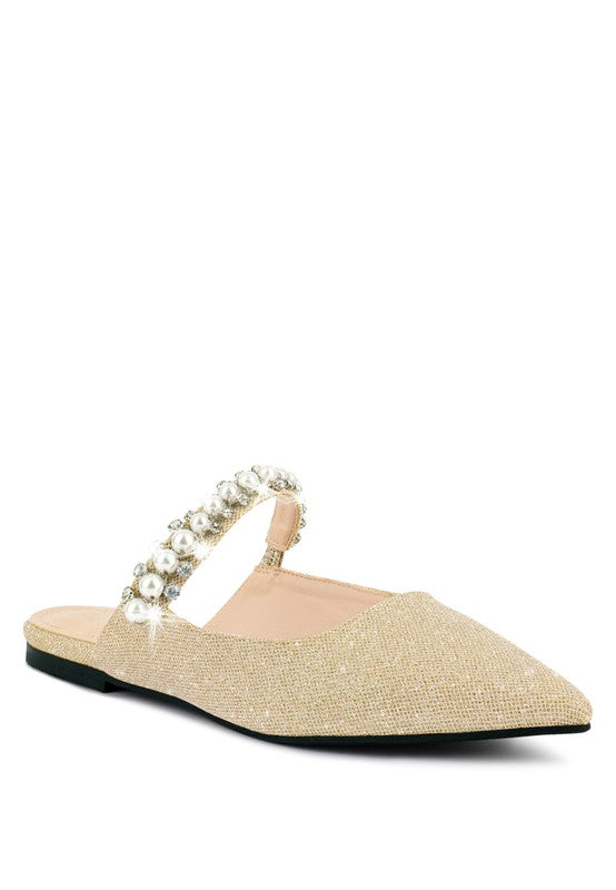 Beige embellished mules with pearl bead strap across the vamp and black sole