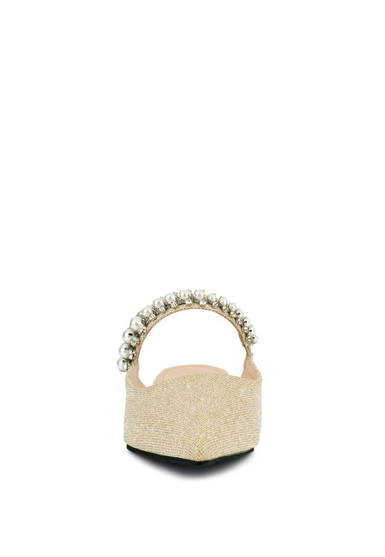 Beige mule with pearl-bead strap at the heel and black outsole