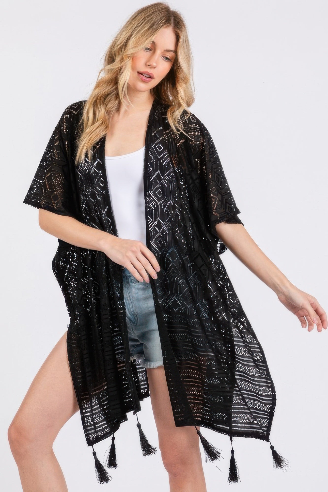 Black geometric tassel cover-up with draped fit and dangling fringe trim