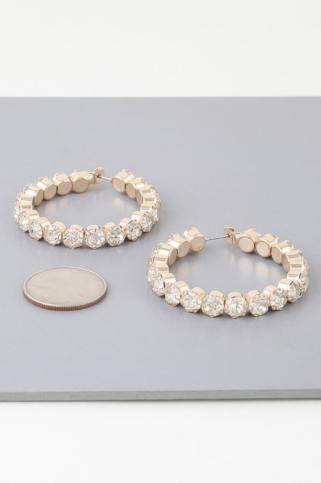 Geometric rhinestone hoop earrings, gold-tone; textured clear stone links
