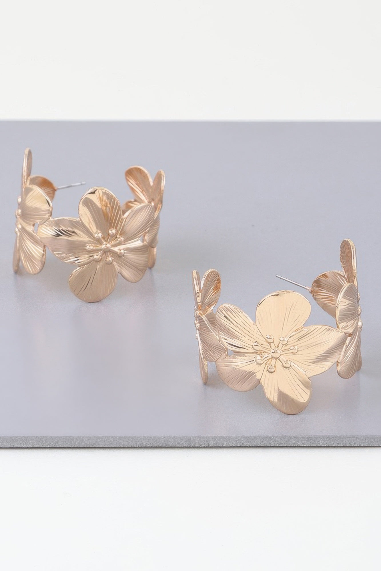 Goldfarbene Florale Creolen-Ohrringe mit Blütenblättern und feinen Musterlinien