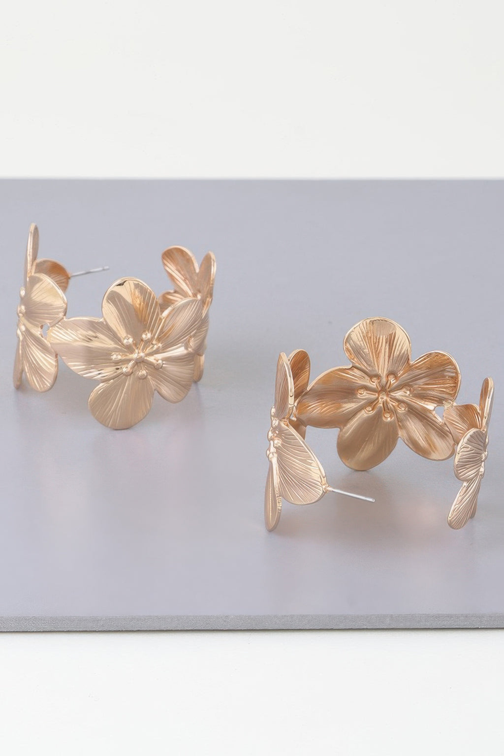 Goldfarbene Creolen-Ohrringe mit floralen Blütenformen und dünnem Steckstift