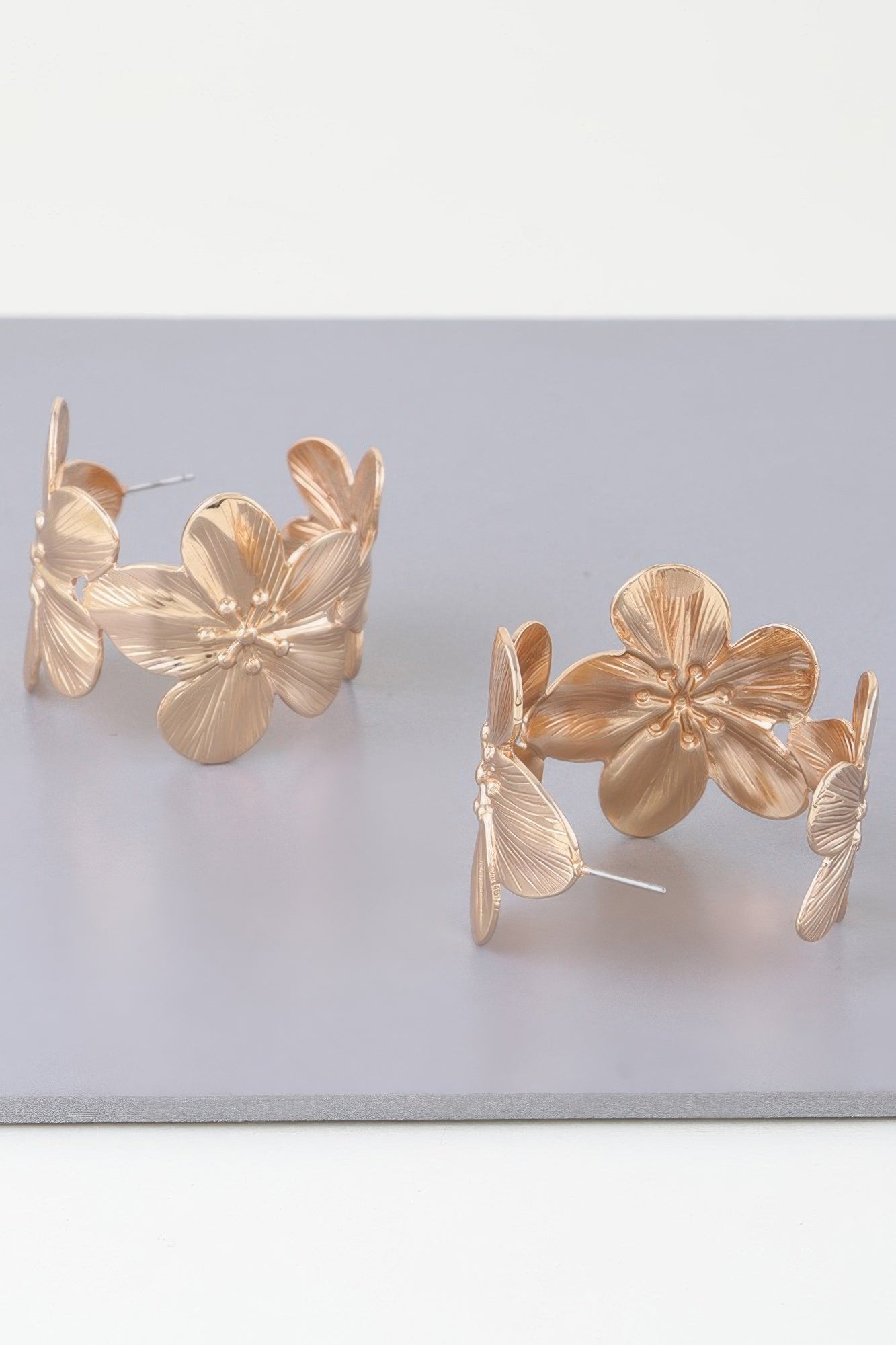 Goldfarbene Creolen-Ohrringe mit floralen Blütenformen und dünnem Steckstift
