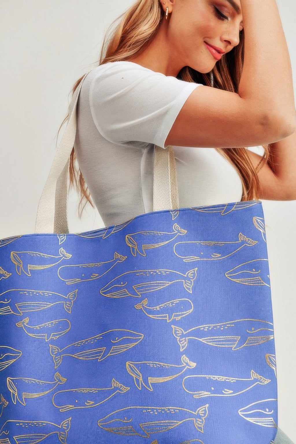 Close-up of royal blue tote bag with gold whale foil pattern