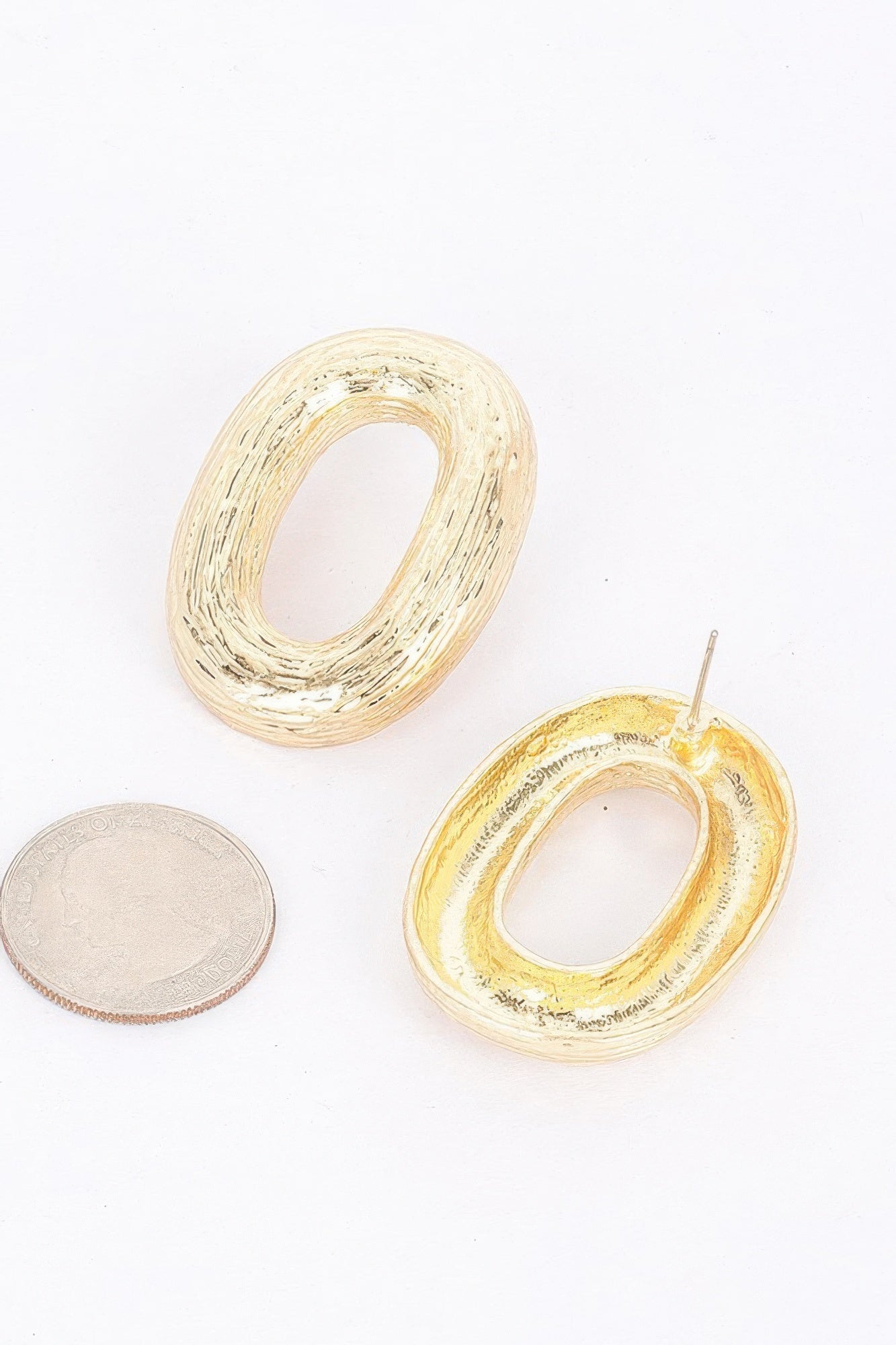 Goldfarbene ovale Creole mit Ohrstecker und strukturierter Metalloberfläche