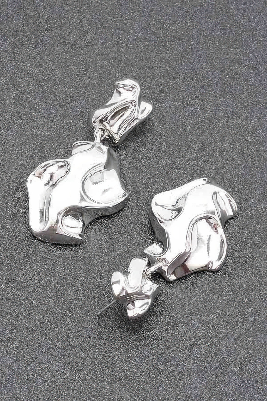 Silver-tone metal earrings, close view of chunky abstract drop and post