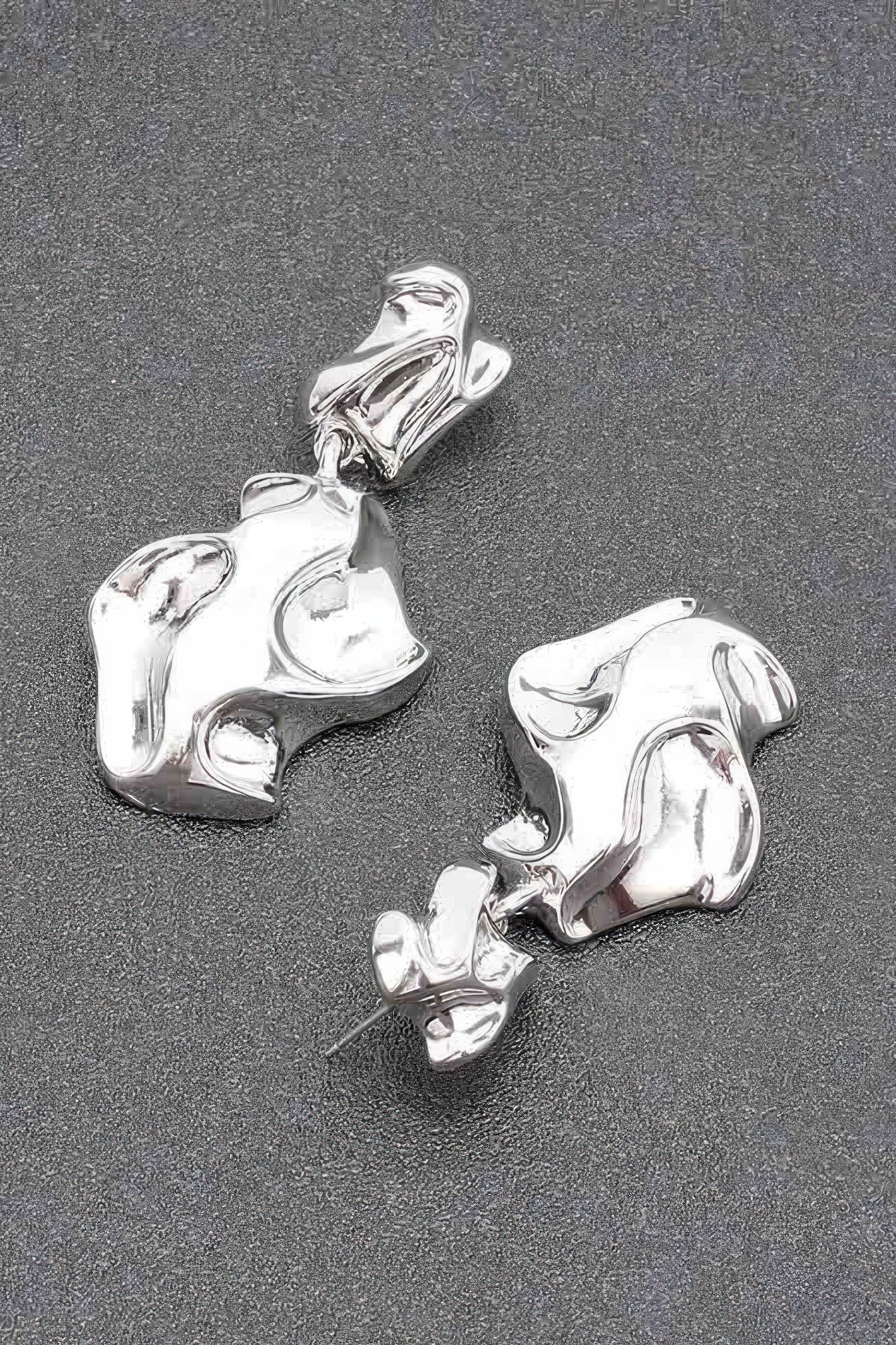 Silver-tone metal earrings, close view of chunky abstract drop and post