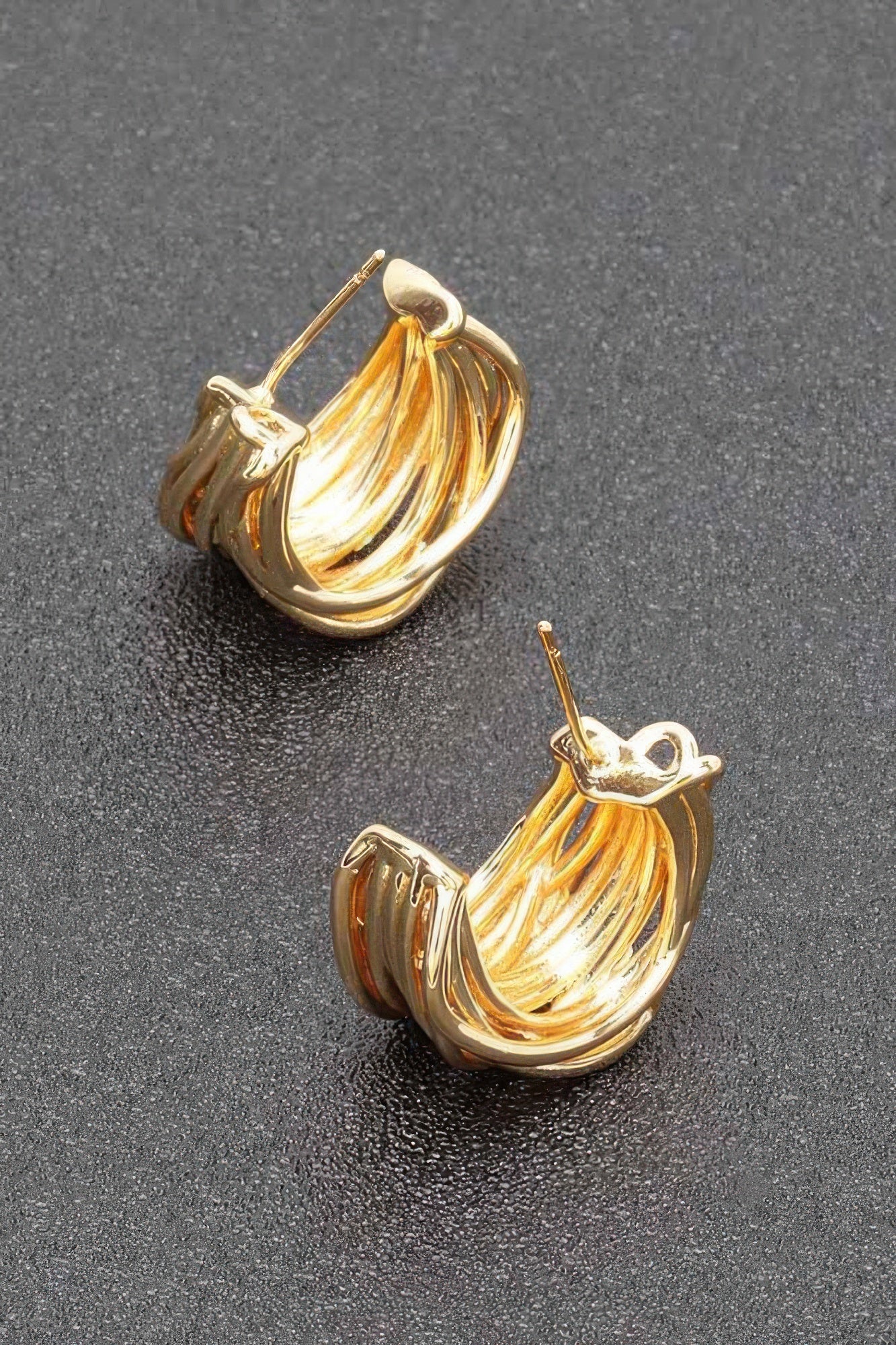 Gold-plated metal earrings with curved twisted loops and small stud backs