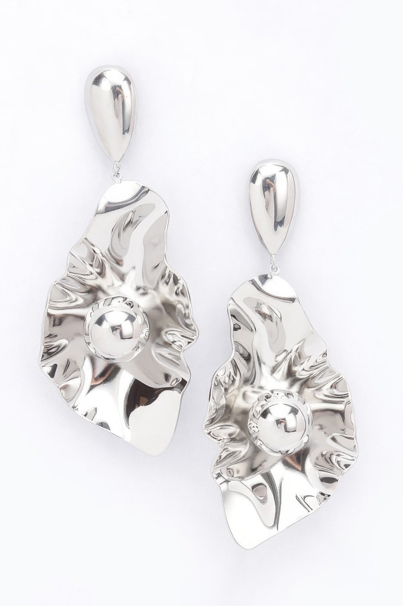 Silver-plated metal earrings with scalloped leaf design, round center, and teardrop dangle