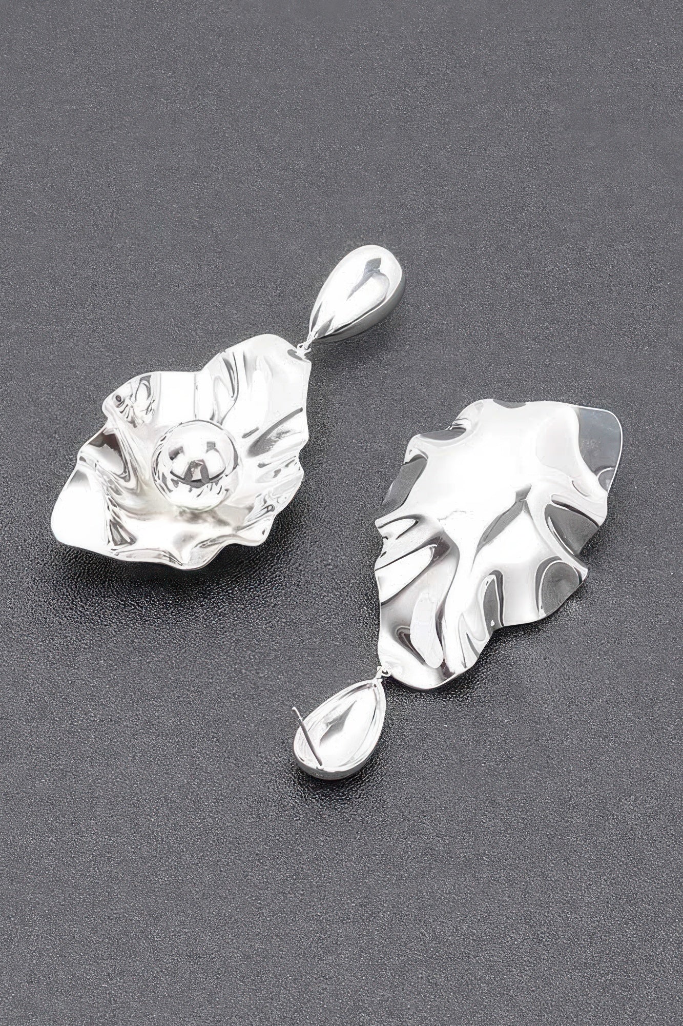 Silver-plated drop earrings with textured leaf studs, round center detail, and oval charm
