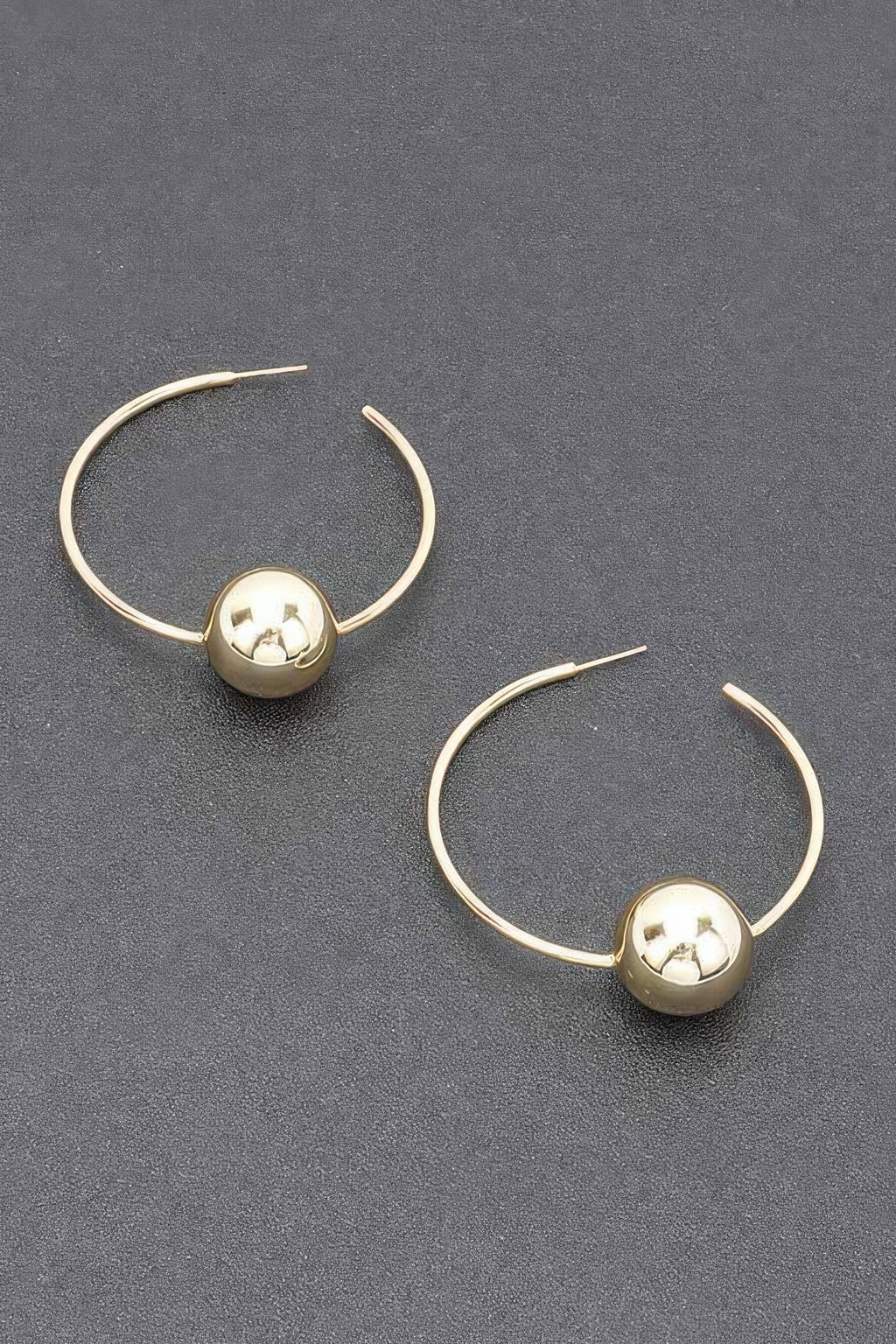 Gold hoop earrings with round ball charm and star-shaped center