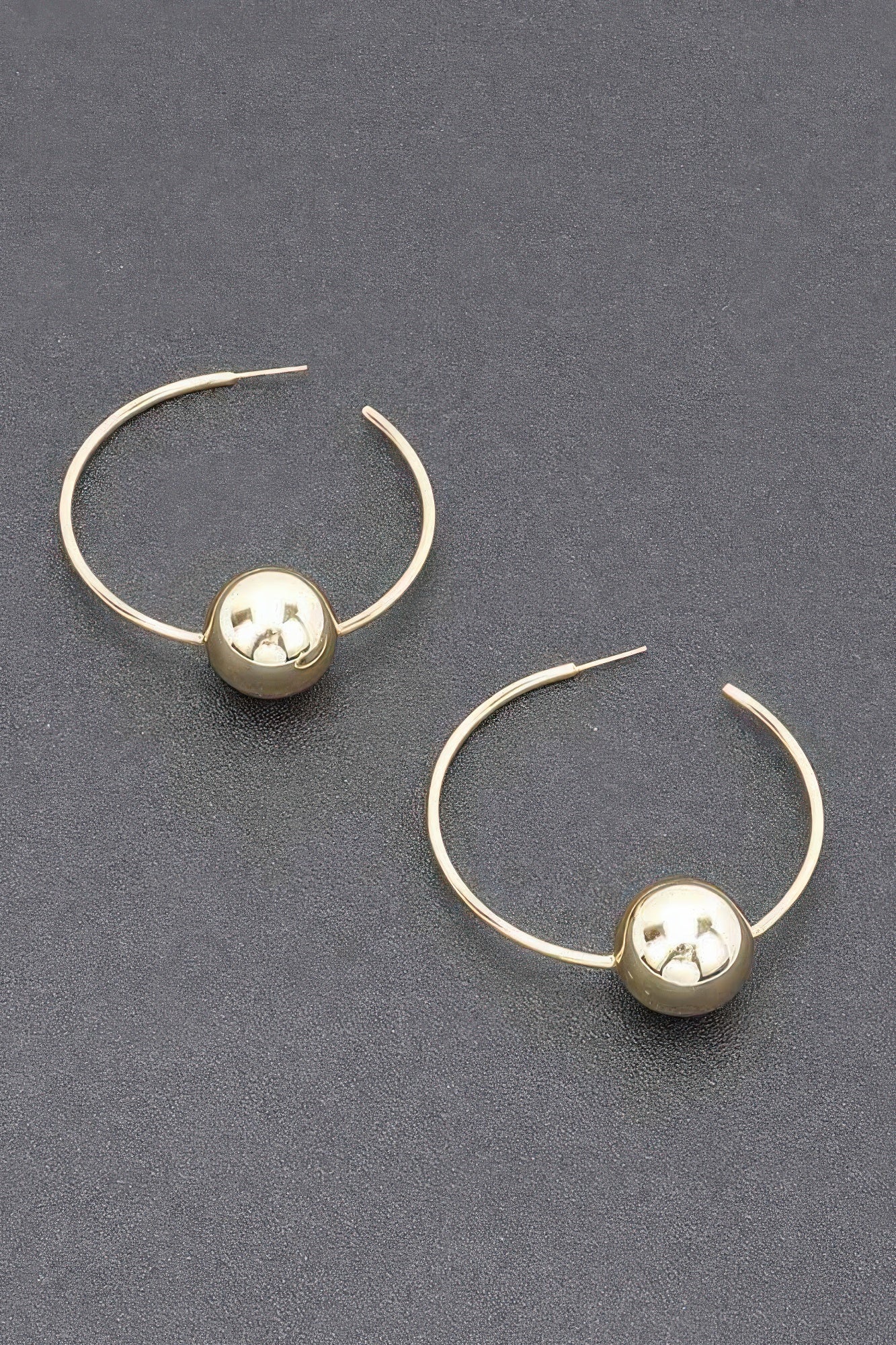 Gold hoop earrings with round ball charm and star-shaped center