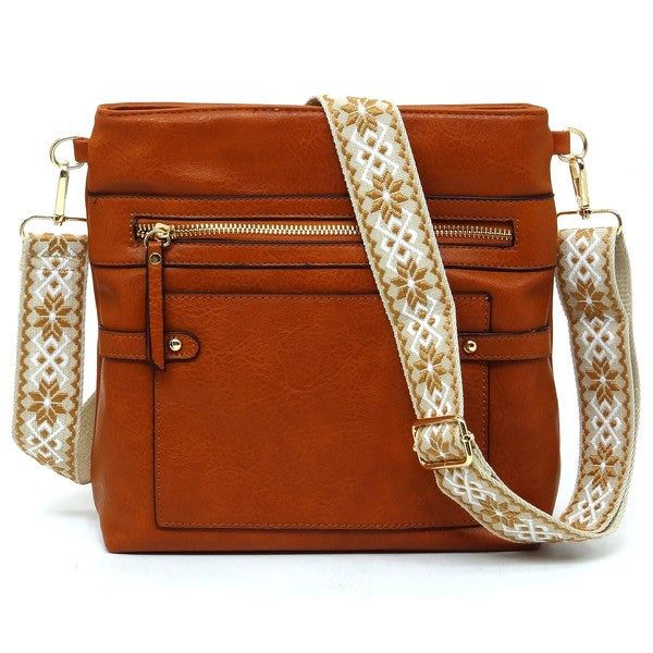 Rust orange crossbody bag with zip pockets and patterned strap