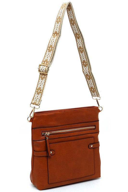 Cognac brown crossbody bag with top zipper and patterned shoulder strap