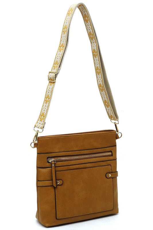 Brown guitar strap crossbody bag with front zip pocket and adjustable patterned strap