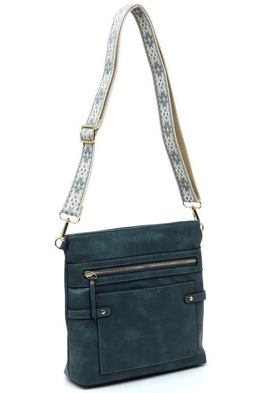 Deep teal guitar strap crossbody bag with front zip pocket and patterned adjustable strap