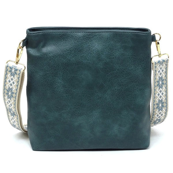 Teal guitar strap crossbody bag front view with top zipper and patterned strap
