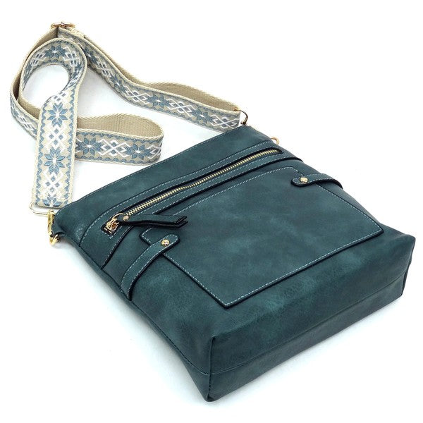 Teal guitar strap crossbody bag angled view with front zip pocket and flap detail