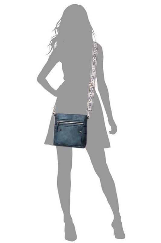 Teal guitar strap crossbody bag worn crossbody with patterned adjustable strap