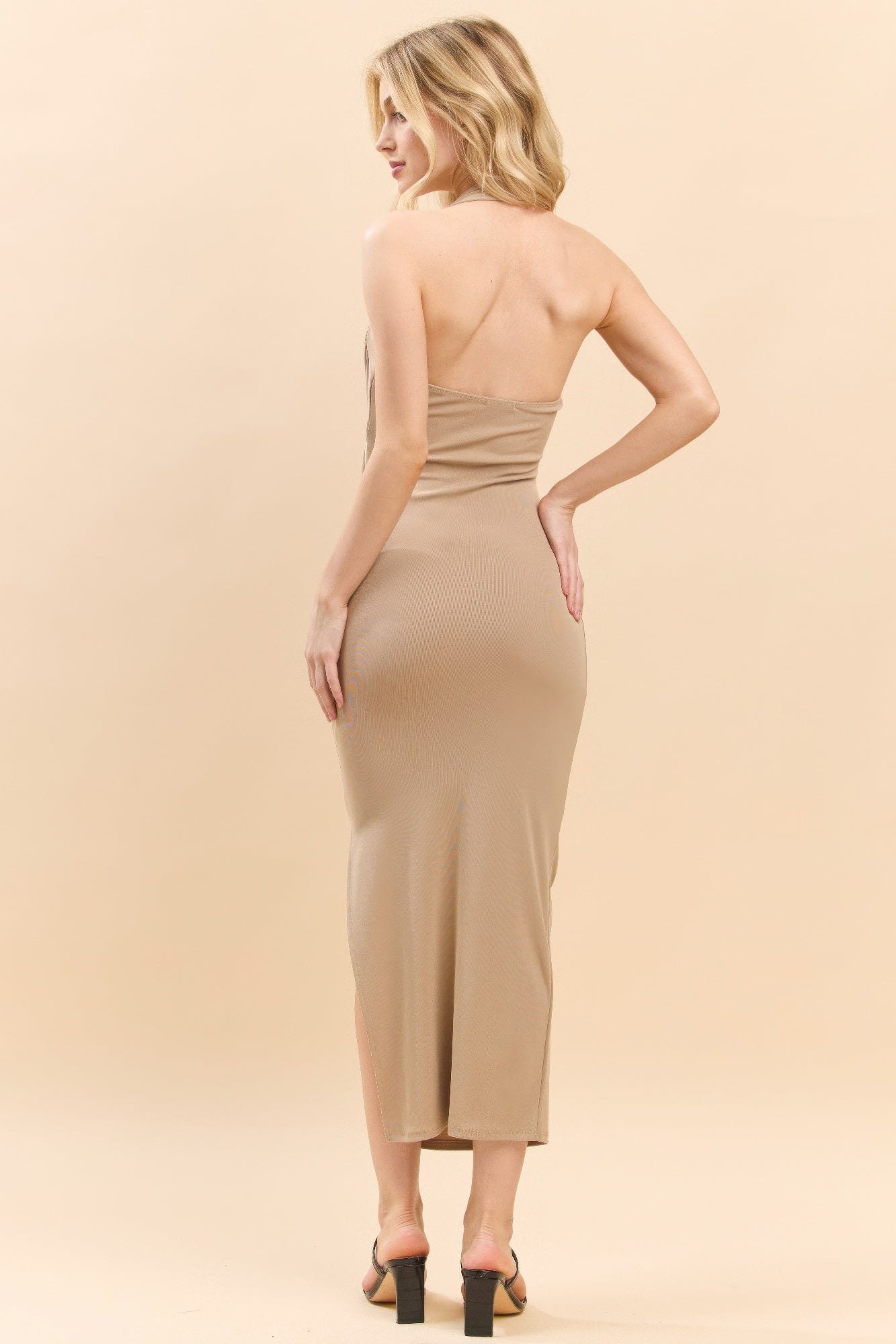 Back view of beige halter ruched midi dress with side slit