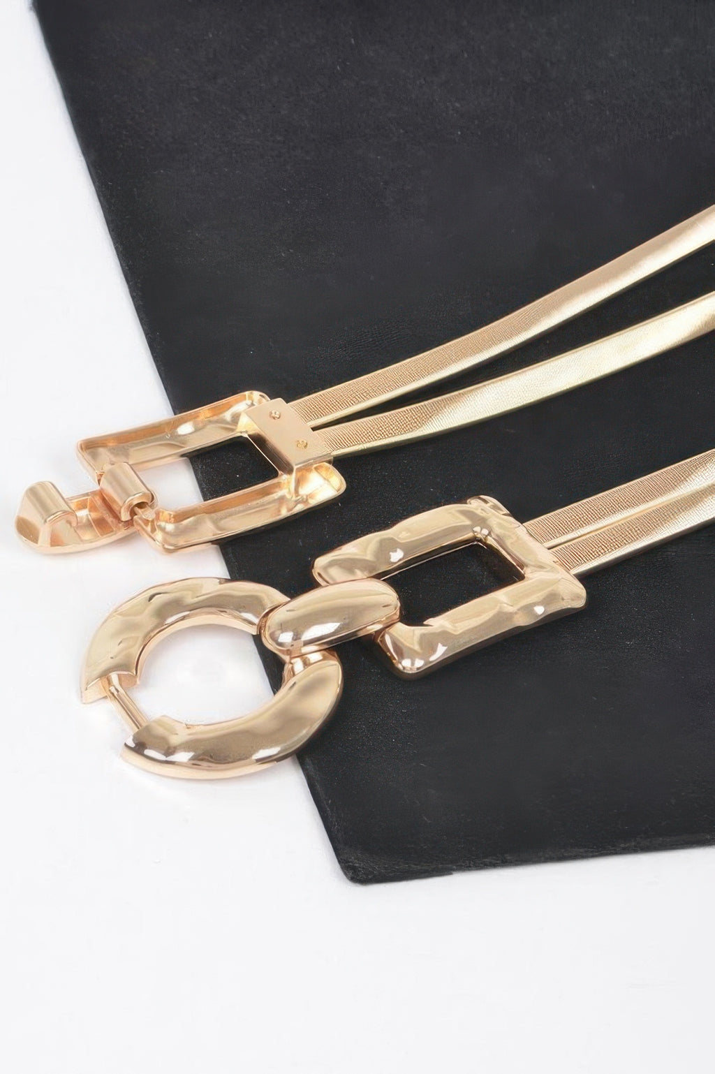 Close-up of gold hammered metal belt buckle with oval ring and side plates