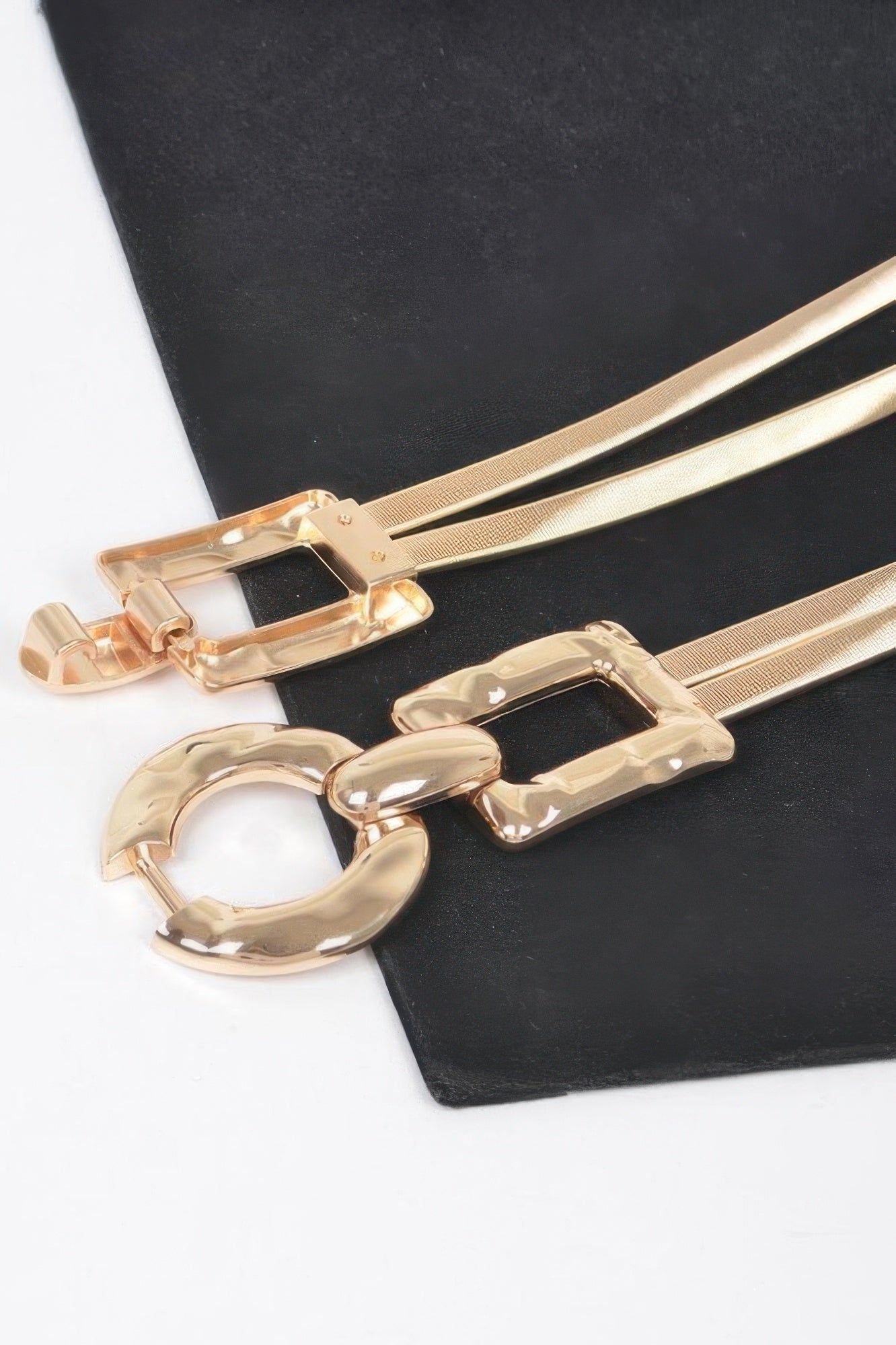 Close-up of gold hammered metal belt buckle with oval ring and side plates
