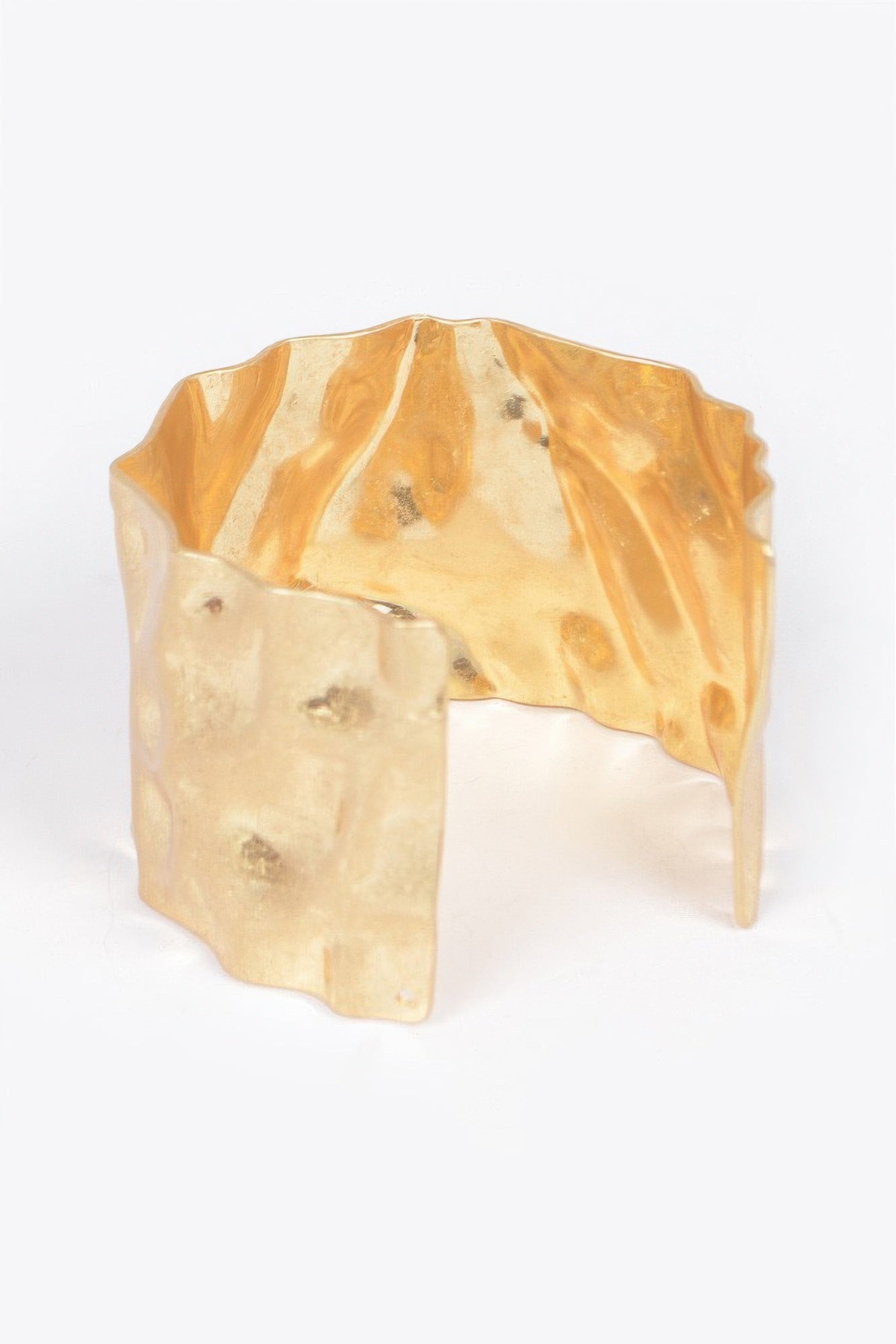 Hammered gold cuff bracelet with bold geometric texture and smooth interior edge