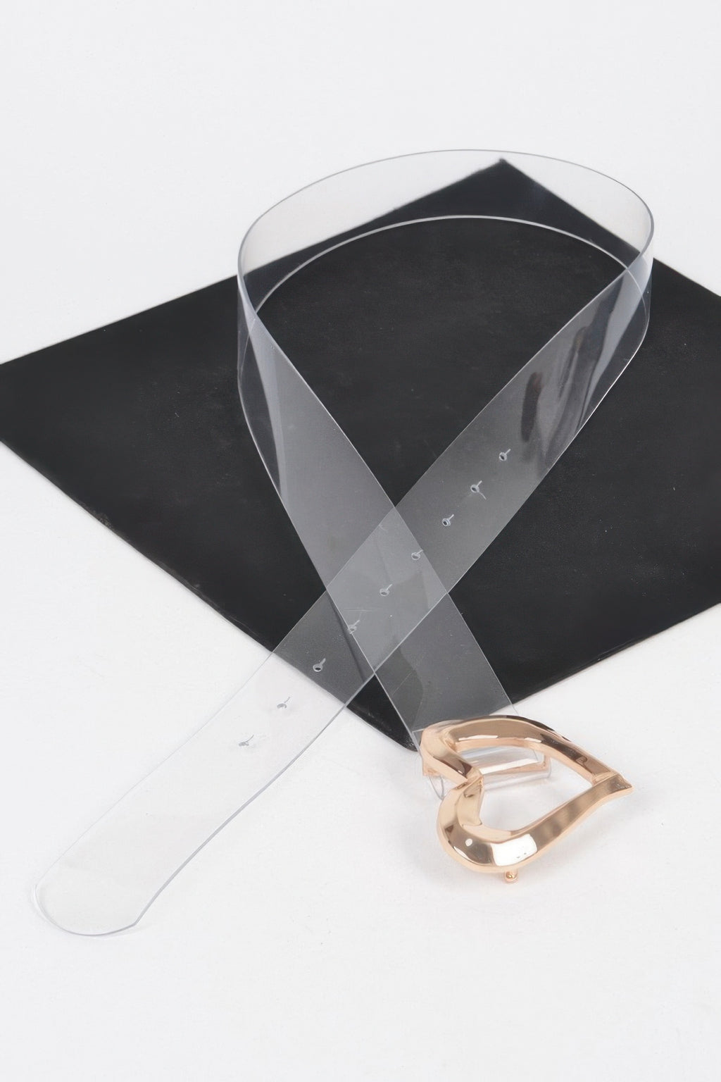 Clear belt with rose-gold heart buckle clasp, heart cutout detail visible