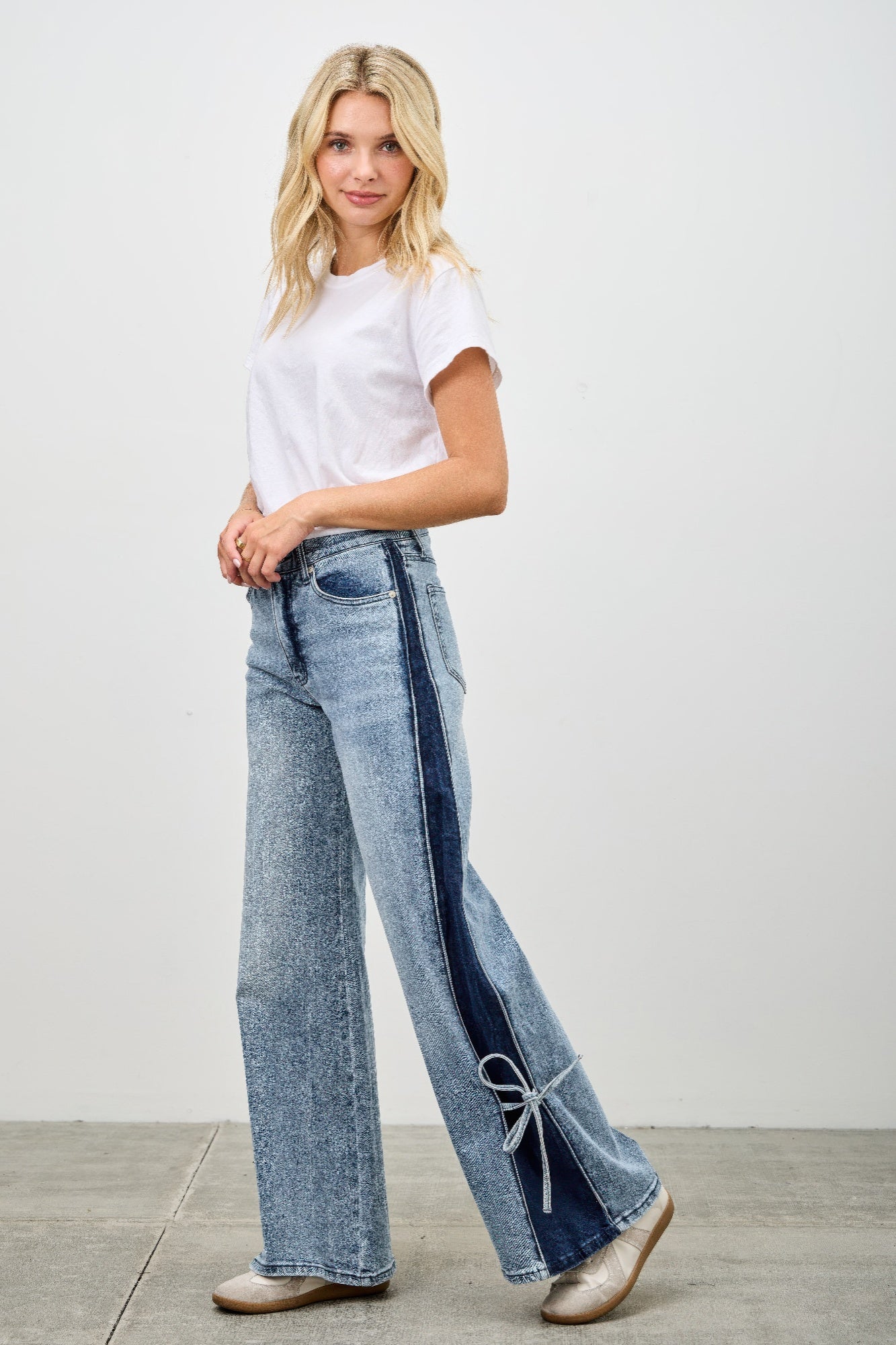 High-rise wide-leg jeans featuring a long contrast stripe and ribbon-tie hem