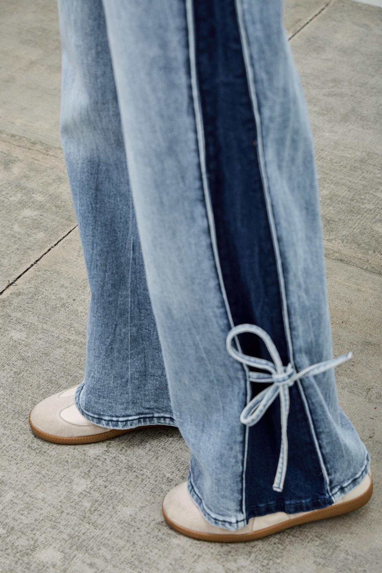 Wide-leg denim jeans with contrast stripe and lace ribbon tie at hem