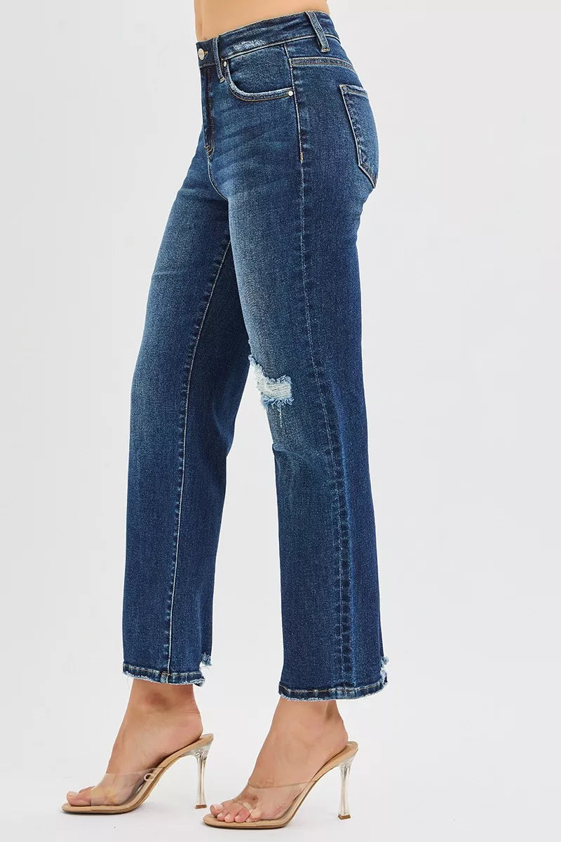 Dark blue high-rise crop slim straight jeans; side view with large knee rip detail