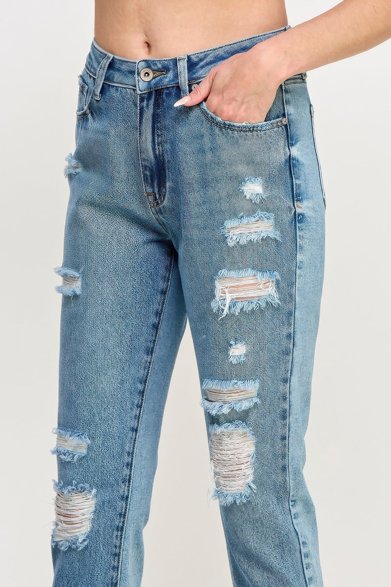 Light blue high-rise jeans close-up: ripped thighs, button fly, front pockets