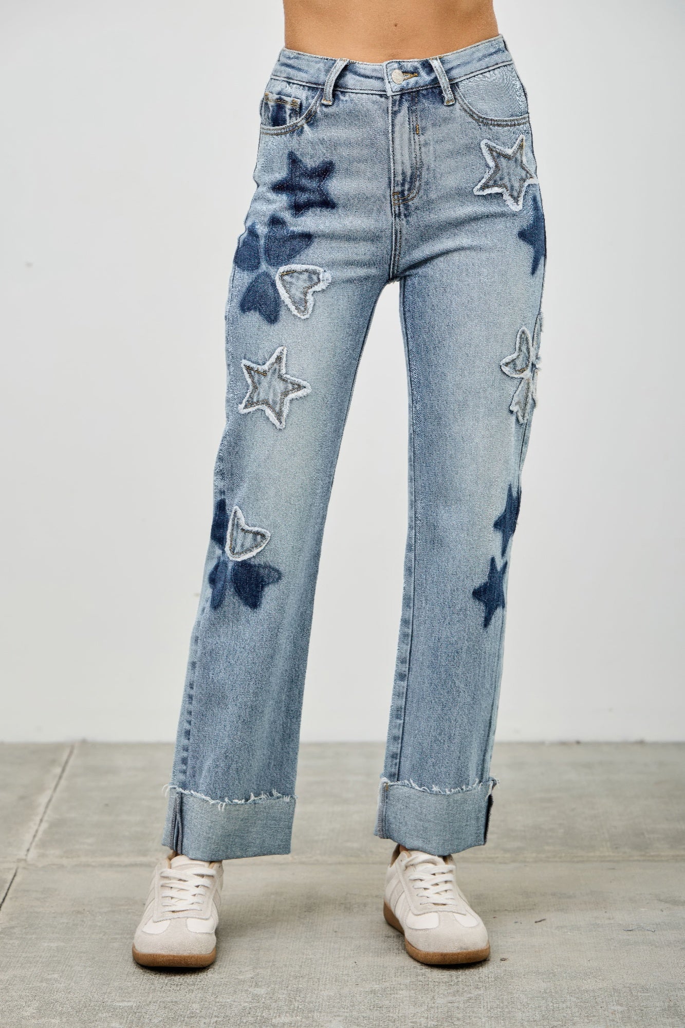 Light blue high-rise dad jeans with star and heart patches and distressed cuffs