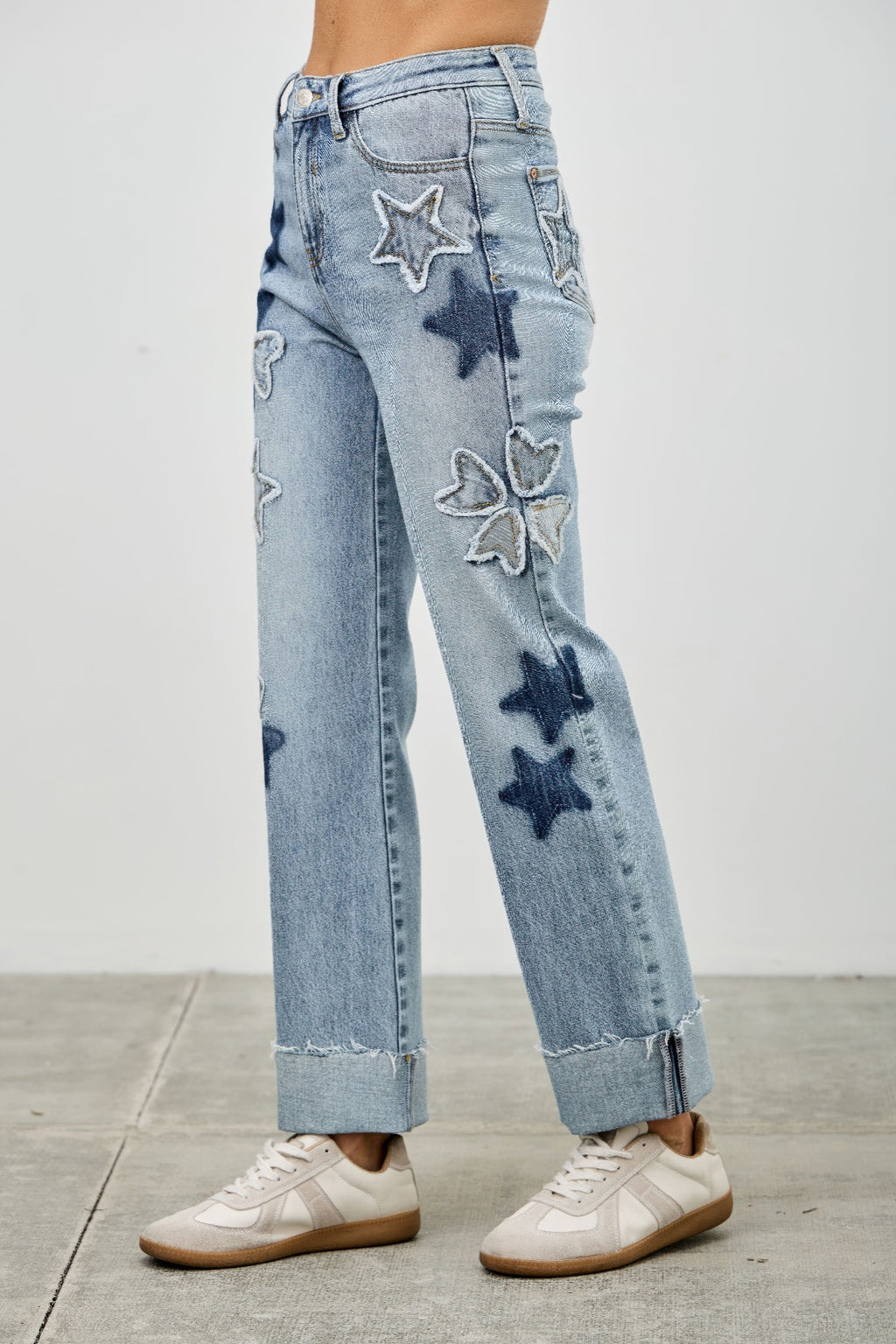 Back view of high-rise dad jeans with stitched star, heart, and clover patches