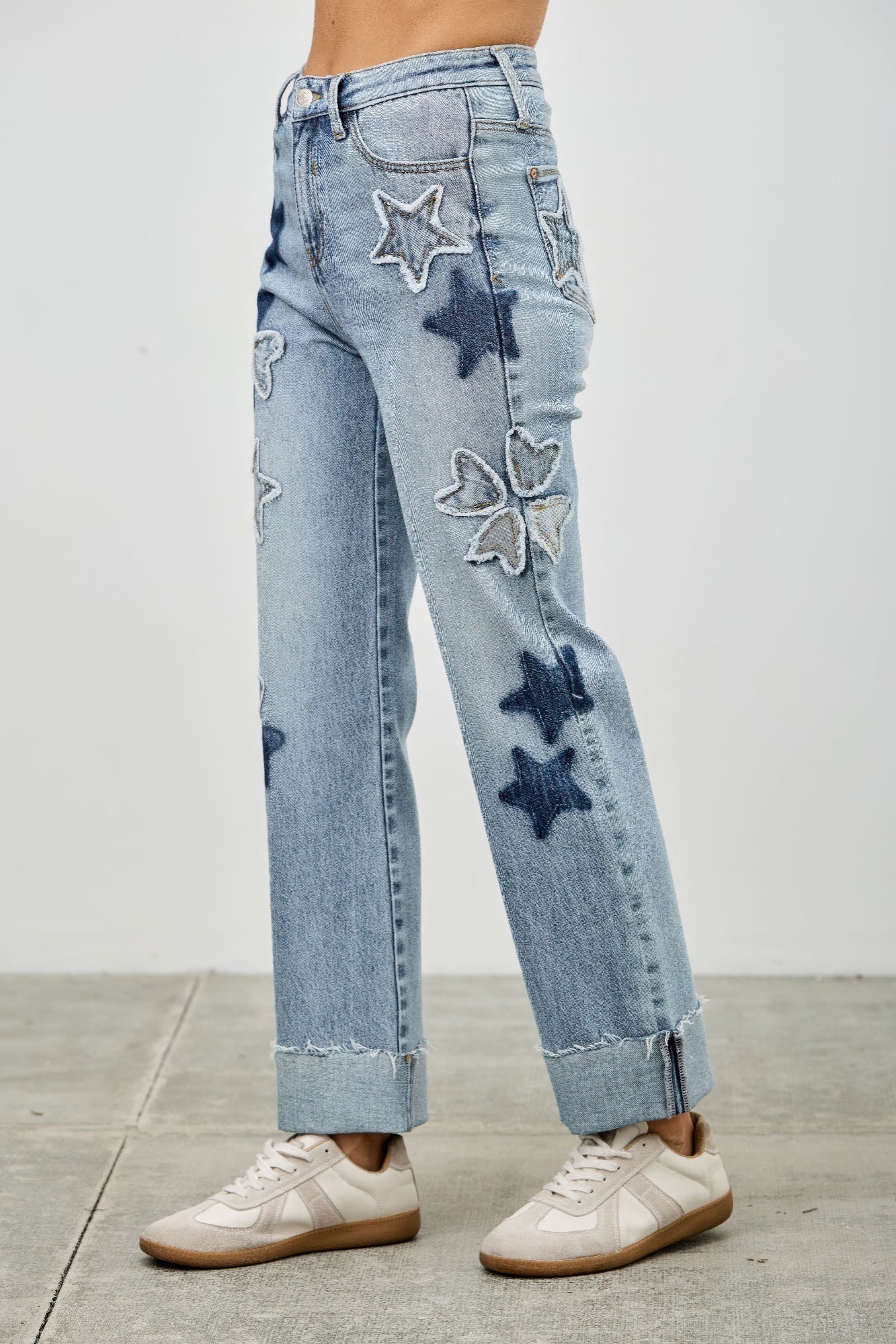 Back view of high-rise dad jeans with stitched star, heart, and clover patches