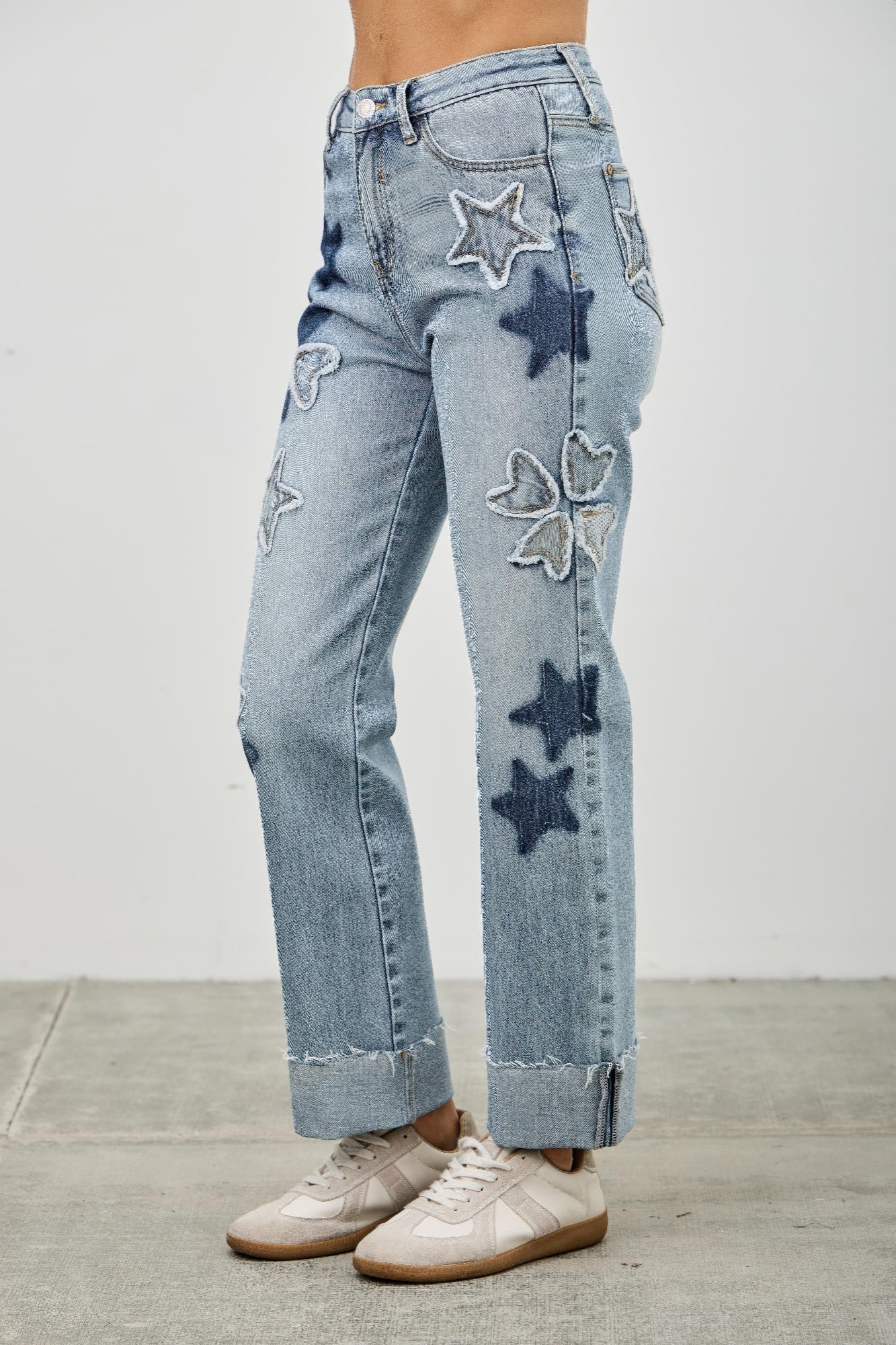High-rise light wash dad jeans with star and heart patches, cropped and cuffed