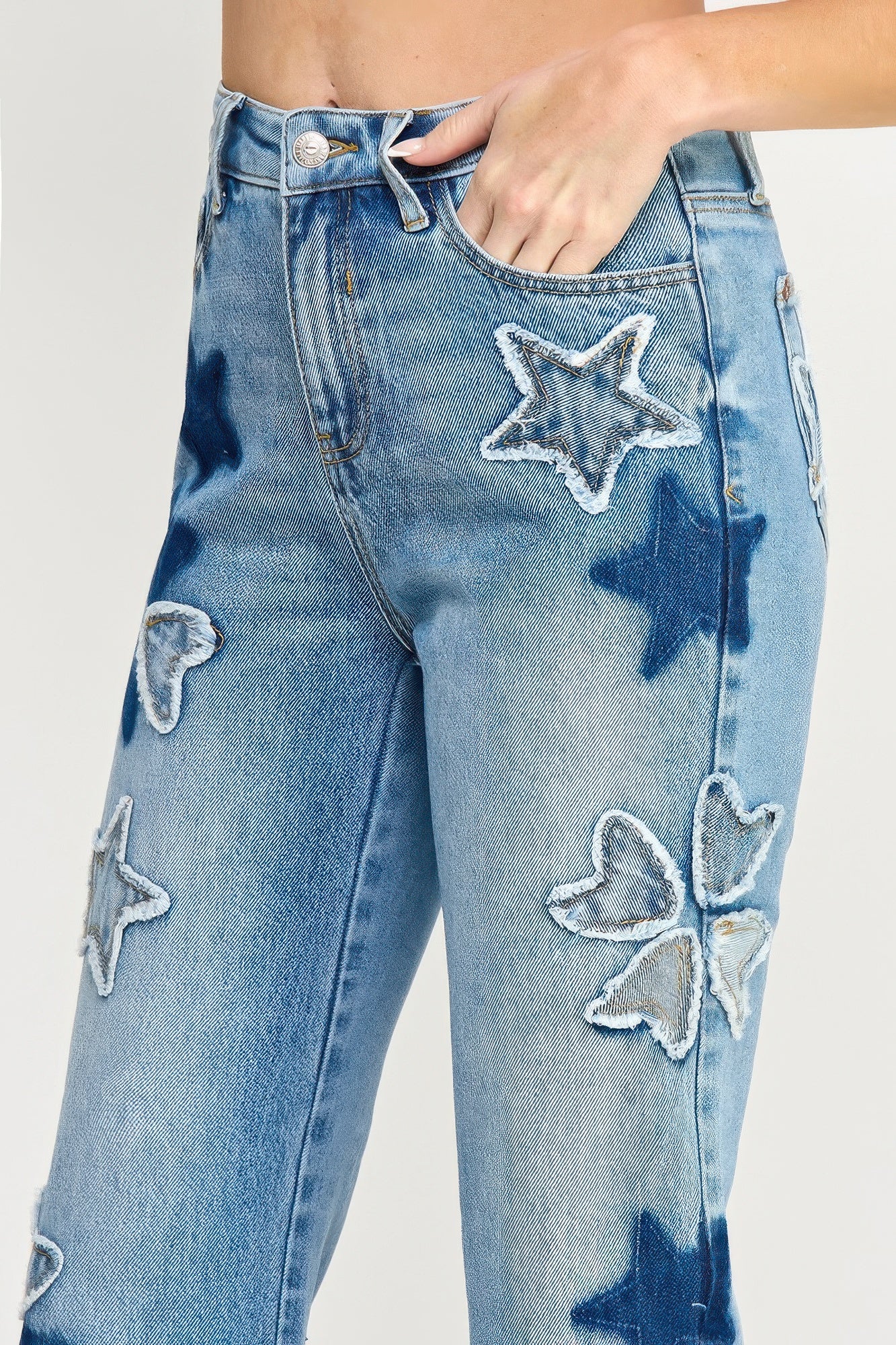 Close-up front: high-rise dad jeans with embroidered star and heart patch details