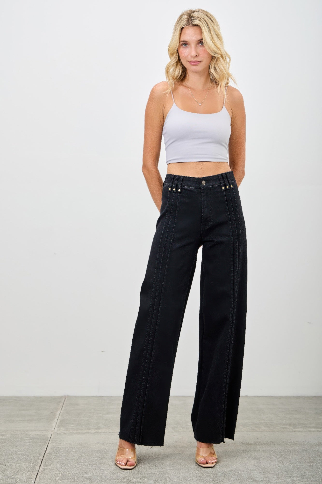 High-rise straight jeans in dark black denim, front seam lines, studded waistband