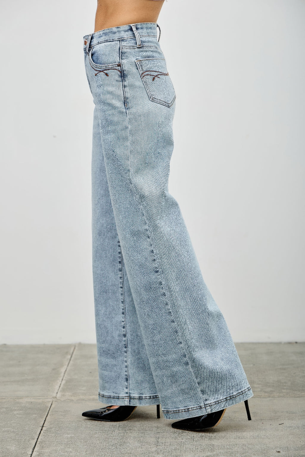 High rise wide-leg jeans side close-up, light blue denim with front patch pocket