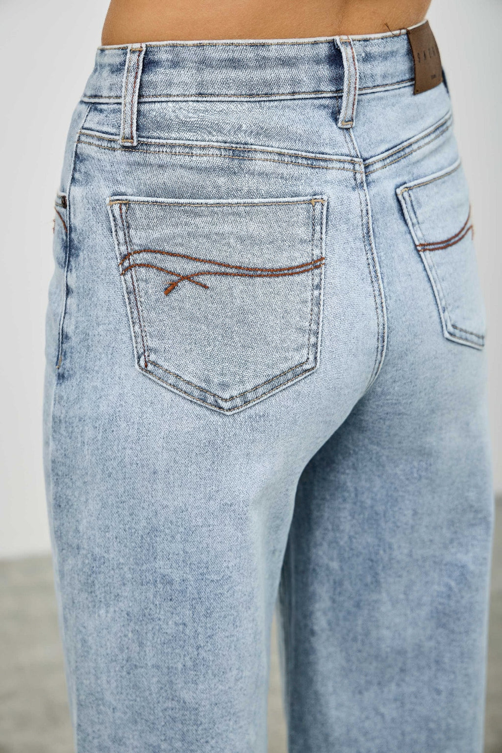 High-rise denim jeans with back yoke and welt pocket, light wash stitching detail