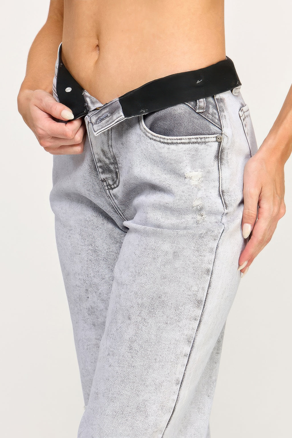 High-rise acid grey jeans waistband and patch pockets; close-up of fly.