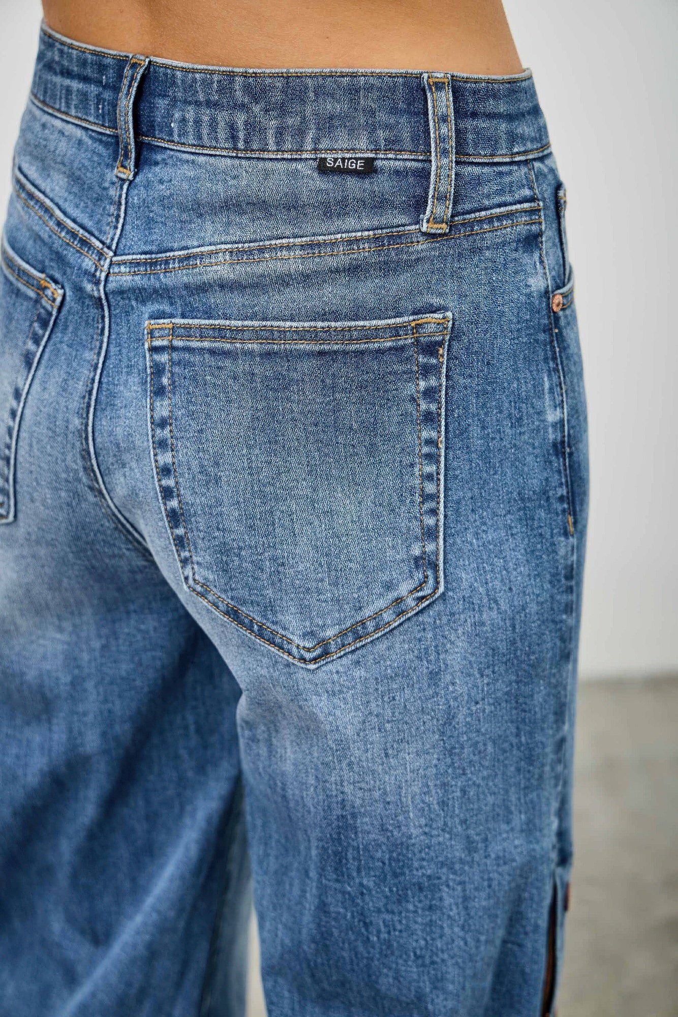 Back view of high-rise wide-leg jeans in blue denim with patch pocket