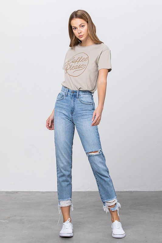 High-waist ripped tapered jeans, medium wash denim with knee tear and frayed hem