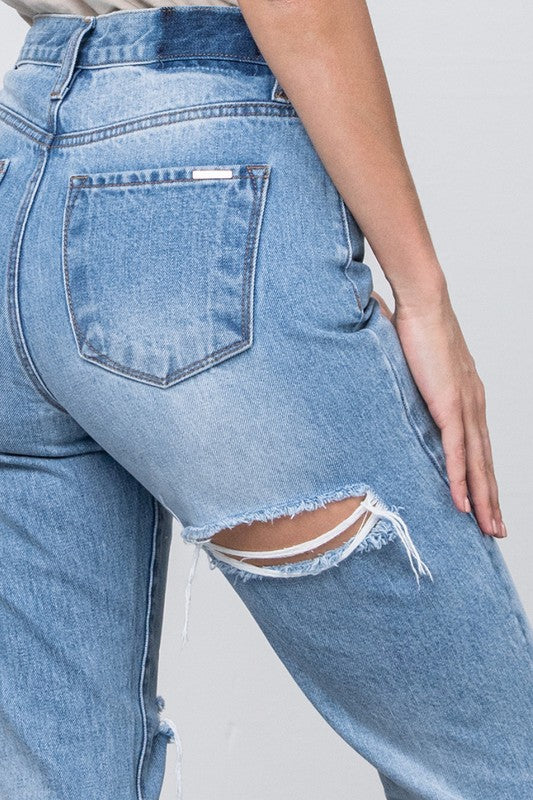 Medium-wash high-waist tapered jeans, back pocket, distressed knee and frayed hem