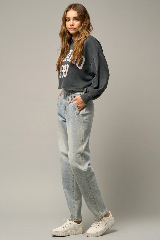 Light high-waisted balloon jeans in side profile with belt loops and hand-ready pockets