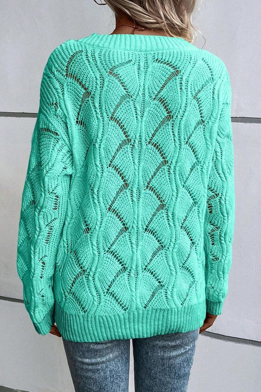 Green hollow-knit sweater back view with openwork pattern and ribbed neckline hem