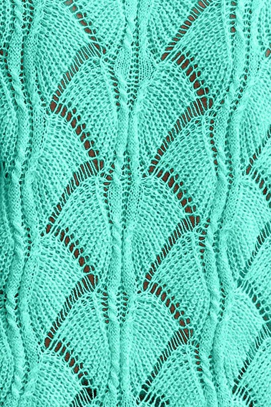 Green hollow-knit close-up with openwork leaf-like pattern and V-stitch texture